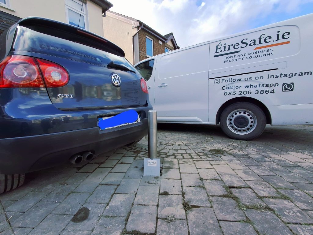 VW Golf GTI protected by a stainless steel telescopic driveway bollard for vehicle theft prevention.